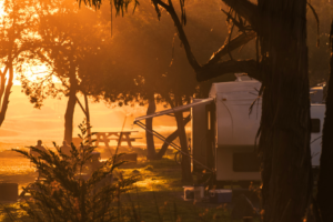 Full-time RVers watching the sunset over the lake from lawn chairs next to their RV