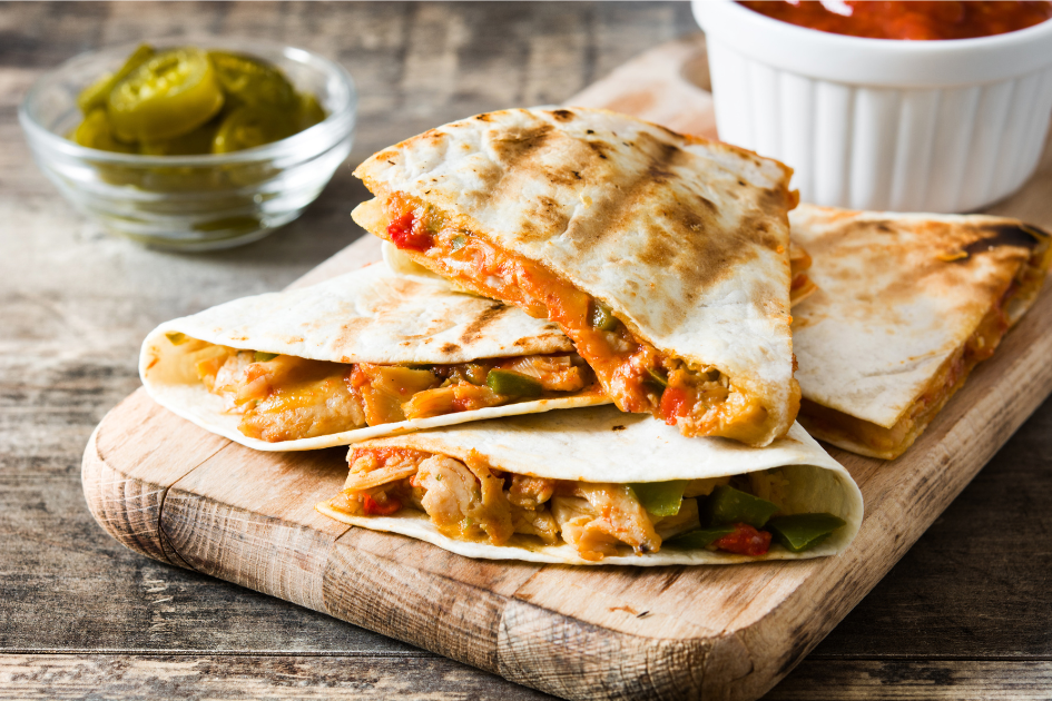 Delicious quesadillas made while camping, on a wooden serving block.