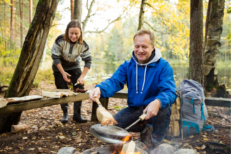 Campers cooking dinner around the campfire.