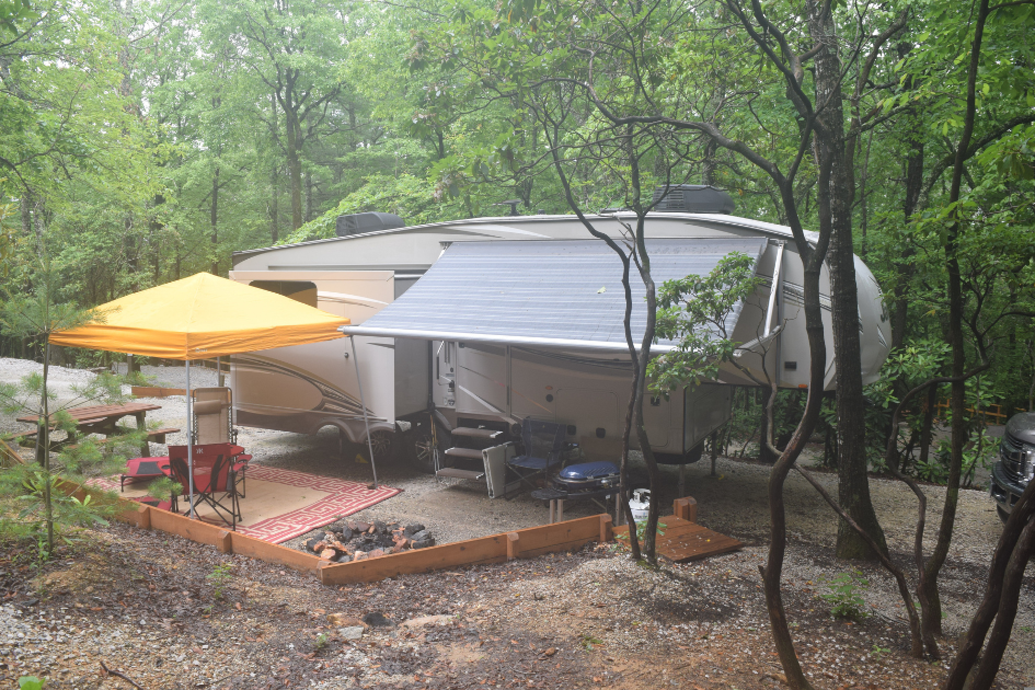 An RV parked off grid with a picnic like outdoor setup.