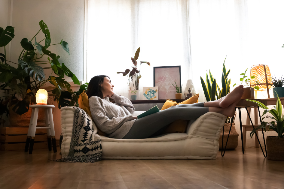 Woman cozy at home, dreaming of springtime from her couch
