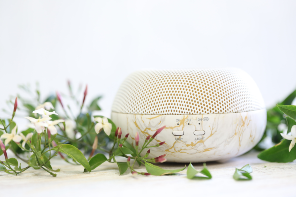 Essential oil diffuser with vines wrapped around it on a white table