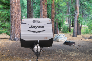 Jayco Jay Flight travel trailer parked in a wooded campsite